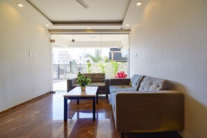 Uma sala de estar moderna com um sofá, uma mesa e um vaso de planta.