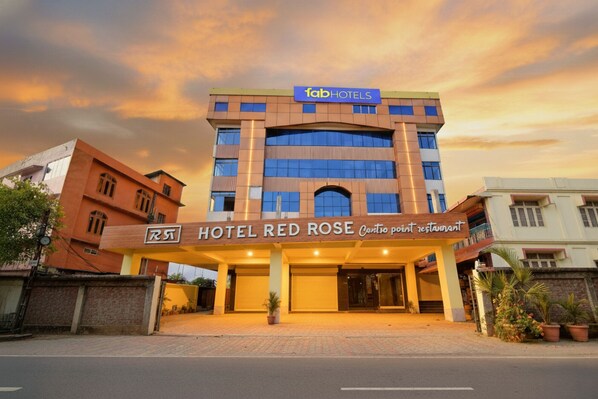 A hotel with a modern facade, a prominent sign for 'Hotel Red Rose', and a 'Cartio point restaurant' indicated on the entrance. - Fabhotel Red Rose (Guwahati)