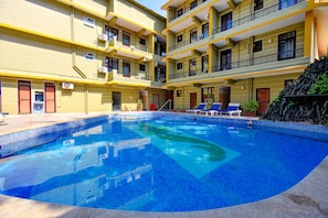 A hotel with a swimming pool, multiple balconies, and a small waterfall feature. - FabHotel Kris Resort Calangute Beach (Calangute)