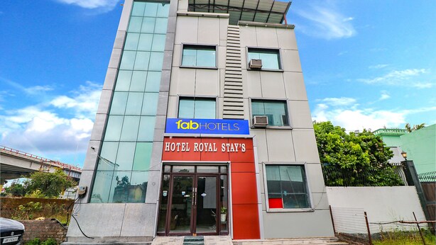 A modern hotel building with a glass facade and a prominent sign for 'Tab Hotels'. - Fabexpress Royal Stays (Rishikesh)