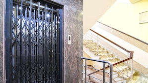 Una puerta de seguridad con teclado, un muro de mármol y una escalera con barandas de madera.