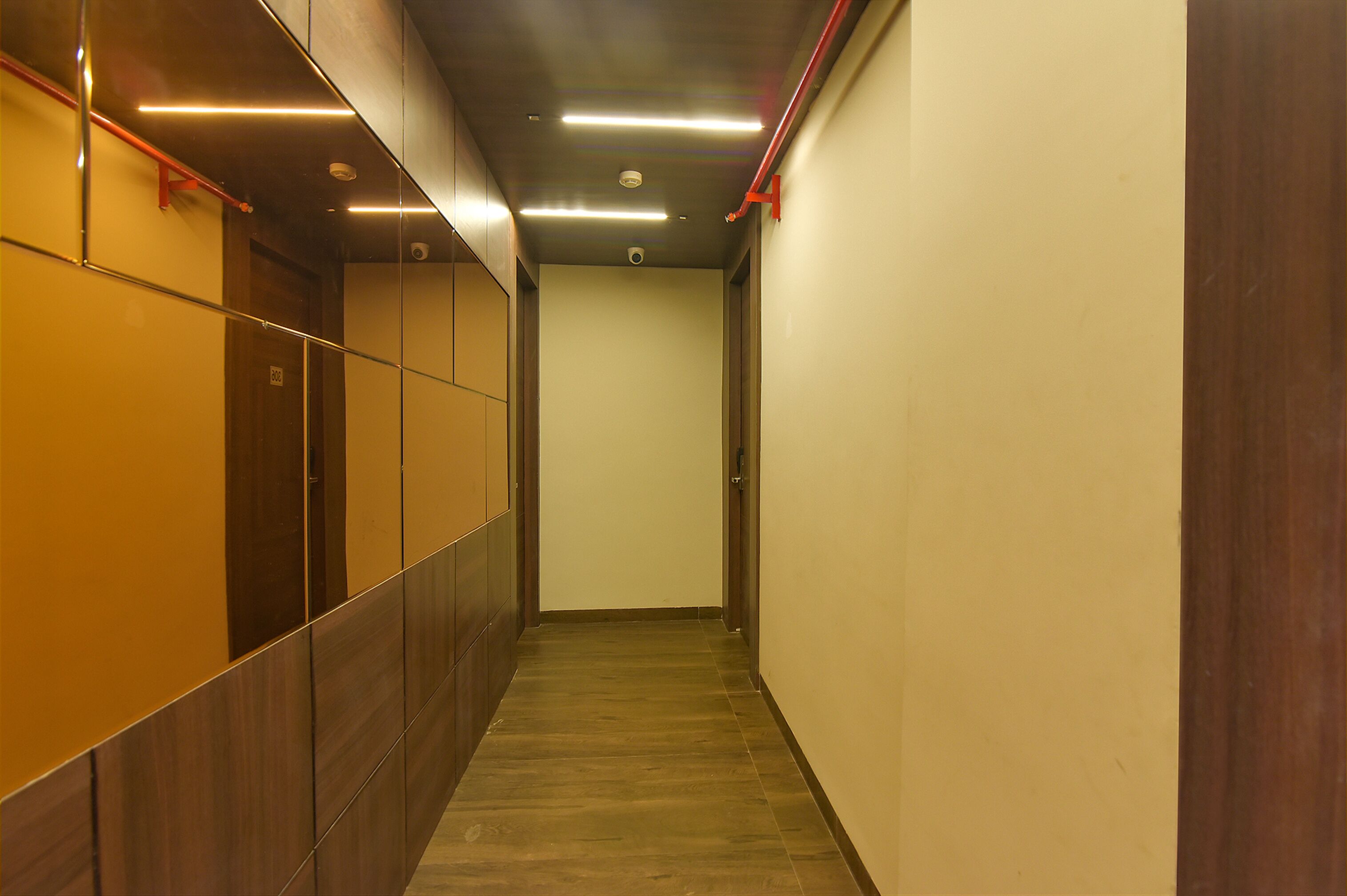 A narrow hallway with wooden paneling on one side and a plain wall on the other.