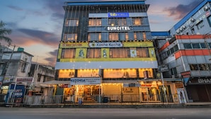 Un edificio de varios pisos con un letrero de 'fab hotels', la marca 'Suncitel' y señalización que dice 'Koshe Kosha'.