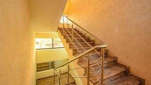 Una escalera con barandilla de metal que sube a un piso superior.