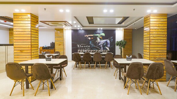 A conference room with a large table, multiple chairs, and a mural on the wall. - Fabhotel Palash (Danapur)