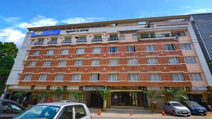 Un hotel de varios pisos con un llamativo letrero 'Fab Hotels', un restaurante 'Citizen' y un establecimiento 'Phoenix Hotel'.