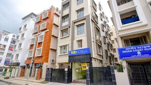 Un hotel de varios pisos con un llamativo rótulo de 'fab hotels', una entrada con portón y un cartel del 'Servicio Costero Indio' al fondo.