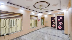 Un vestíbulo amplio con piso de mármol, techo decorativo y ventanas con rejas.