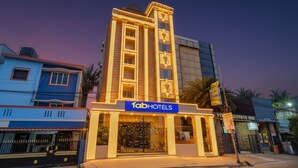 Un hôtel avec une enseigne bien visible portant l’inscription « fabHOTELS » et une entrée bien éclairée.