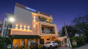 Un hôtel moderne avec une enseigne indiquant « fabHOTELS » et une voiture garée devant.
