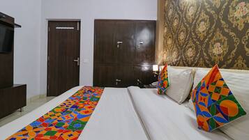 A hotel room with a bed, a wardrobe, and a television.