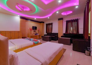 A hotel room with two beds, a sofa, a TV, and a ceiling with colorful lighting. - Via Moti Mahal - Nr. Sarnath Museum (Varanasi)