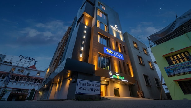 Et moderne hotel med et tydeligt 'fabHOTELS' skilt, en tagterrasse og et skilt for restauranten 'The Atel'.