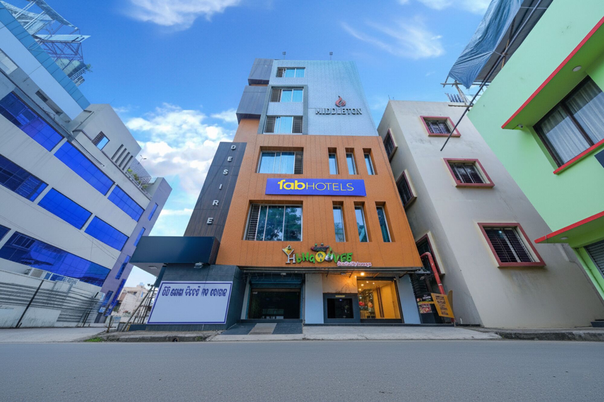 En moderne hotelbygning med et tydeligt skilt, der siger 'fabHOTELS'.