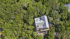 An aerial view of a house surrounded by dense green forest. - Golf course views on Fort Holmes Trail overlooking hole number 10! Upper deck taking in island views (Bald Head Island)