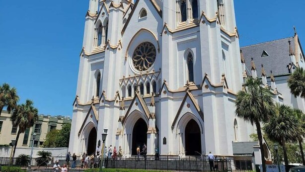Une grande cathédrale dotée de deux hautes flèches et d’une grande fenêtre circulaire au centre.