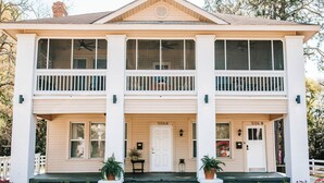 A two-story house with a front porch, two doors labeled 506A and 506B, and a small garden area with potted plants.