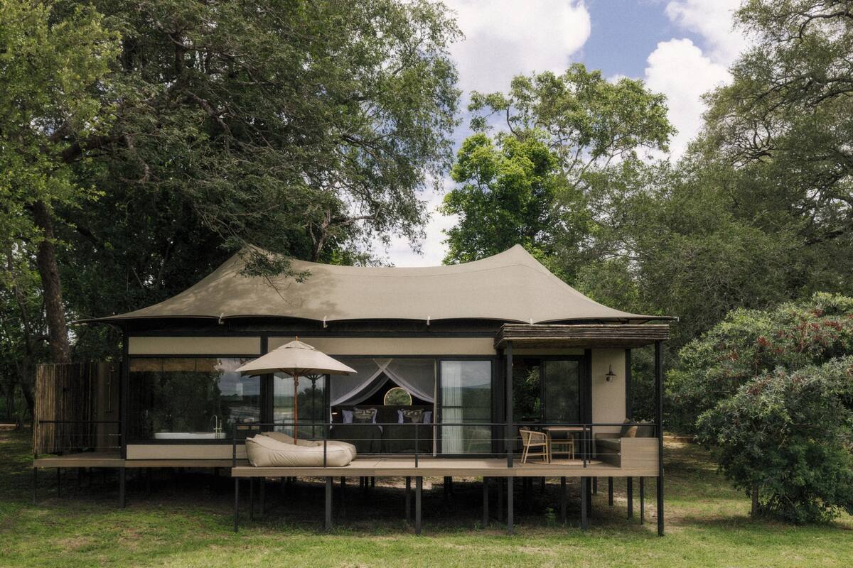Un alojamiento moderno al aire libre con una zona de estar cubierta, piscina y terraza.