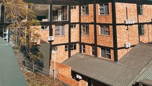 A modern building with a glass facade, brick lower levels, and a flat roof. - Zar Hotel (Kingsburgh)