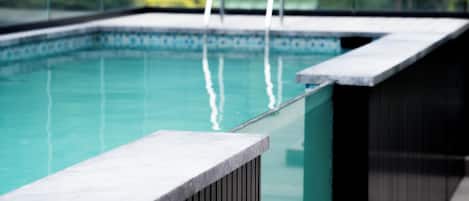 Relax by the pool surrounded by lush greenery and city views.