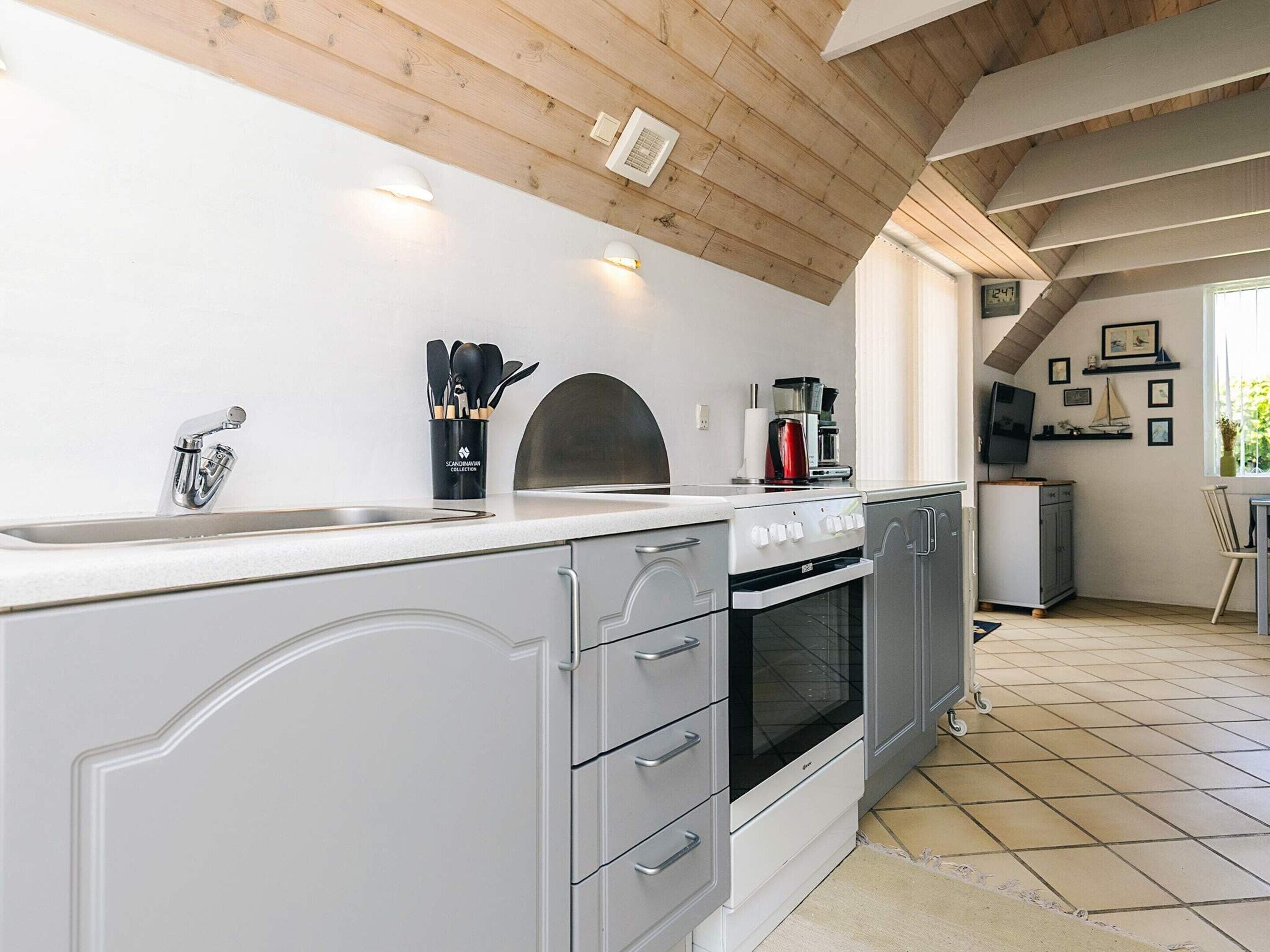 A modern kitchen with a built-in oven, a sink, and a coffee maker.