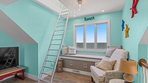 A room with a view of the sea, a loft bed, a TV, and a ladder. - Ohana 3 Bedroom Home in Walnut Island (Grandy)