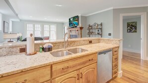 A kitchen with granite countertops, a double sink, wooden cabinets, and a dishwasher. - Echota Woods 221-Entry Level Condo, Gated Resort, Indoor/Outdoor Pools & Hot Tub (Boone)