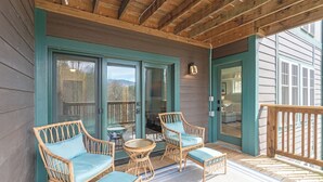 A covered porch with wicker furniture and a view of the interior. - Echota Woods 221-Entry Level Condo, Gated Resort, Indoor/Outdoor Pools & Hot Tub (Boone)