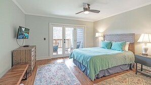 A bedroom with a bed, a ceiling fan, a TV on a wooden dresser, and a view of the outside through a sliding glass door. - Echota Woods 221-Entry Level Condo, Gated Resort, Indoor/Outdoor Pools & Hot Tub (Boone)