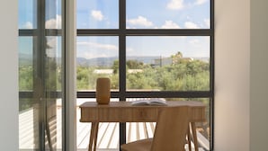 Una habitación con un amplio ventanal que ofrece vistas del paisaje y edificios.