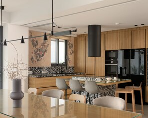 Une cuisine moderne dotée d’un îlot central, de meubles en bois et d’un réfrigérateur noir.