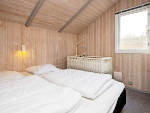 A room with two beds, a crib, a nightlight, and a window. - 6 Person Holiday Home in Borkop (Borkop)