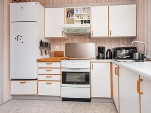 A compact kitchen with a refrigerator, stove, oven, microwave, and a coffee maker. - 6 Person Holiday Home in Borkop (Borkop)