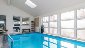 A swimming pool with a view of the outdoors, a bench, and a ladder. - 4 Star Holiday Home in Vaeggerlose (Vaeggerlose)