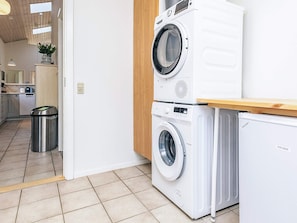 A laundry area with stacked washing machines and a compact dryer.