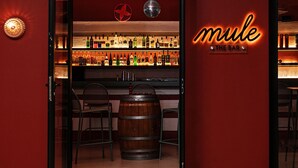 Un bar con un letrero de neón que dice "mule THE BAR".