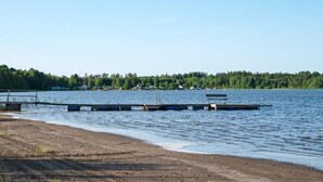 Une vue sur le lac, avec une jetée qui s’avance dans l’eau, le tout entouré d’une zone boisée.