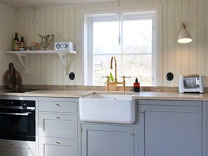 A kitchen with a built-in sink, a toaster, and a radio on the countertop. - 4 Star Holiday Home in Nassjo (Nassjo)