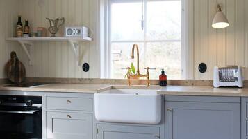 A kitchen with a built-in sink, a toaster, and a radio on the countertop.