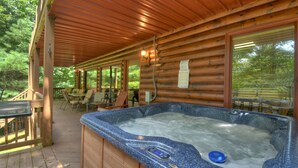 A wooden cabin with a hot tub, outdoor seating, and a covered deck. - Experience Lakeview Retreat, where pets are pampered by the shimmering waters. Unwind in a hot tub, enjoy WiFi, and  a full game room w/ pool table (Ellijay)