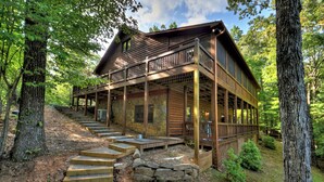 A wooden cabin with a stone foundation, wooden deck, and a staircase leading to the entrance. - The Retreat is pet-friendly with 3 King beds, Hot Tub, Fire-pit, pool table and minutes from downtown Blue Ridge (Blue Ridge)