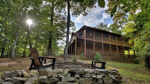 A cabin with a stone staircase leading to a wooden deck, surrounded by trees and a stone wall. - The Retreat is pet-friendly with 3 King beds, Hot Tub, Fire-pit, pool table and minutes from downtown Blue Ridge (Blue Ridge)