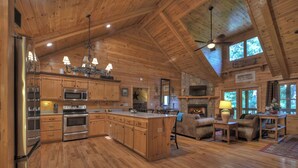 A spacious kitchen with wooden cabinets, stainless steel appliances, and a large island. - The Retreat is pet-friendly with 3 King beds, Hot Tub, Fire-pit, pool table and minutes from downtown Blue Ridge (Blue Ridge)