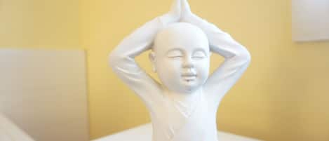 A white statue of a figure in a meditative pose.