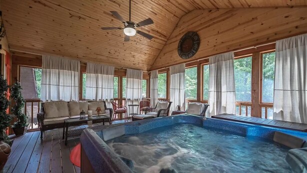 A wooden cabin with a hot tub, seating area, and large windows. - Experience the allure of Roost on the Ridge a pet-friendly sanctuary with hot tub, firepit, ping pong, spacious screen porch, and WiFi (Ellijay)