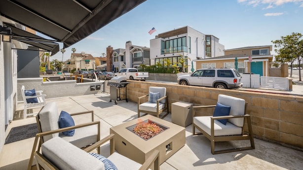 Une terrasse extérieure avec des sièges, un foyer et une vue sur la rue et les bâtiments.