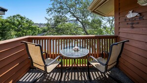 A wooden deck with a glass table and two chairs, overlooking a green landscape and buildings. - Arrowhead 315 in Kingston w/Elevator,Pool,beach (Myrtle Beach)