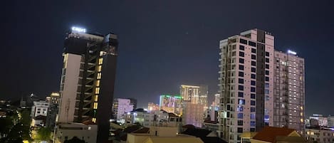 A nighttime cityscape with high-rise buildings, including a hotel with a prominent sign.