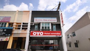 Hotel Iskandar mit auffälligem rot-weißen Schild, einem gut sichtbaren Eingang und freiem Blick auf die Straße.