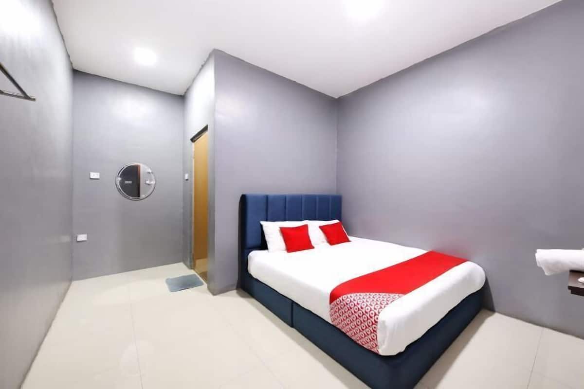 A modern hotel room with a bed, a TV, and a small table with toiletries.